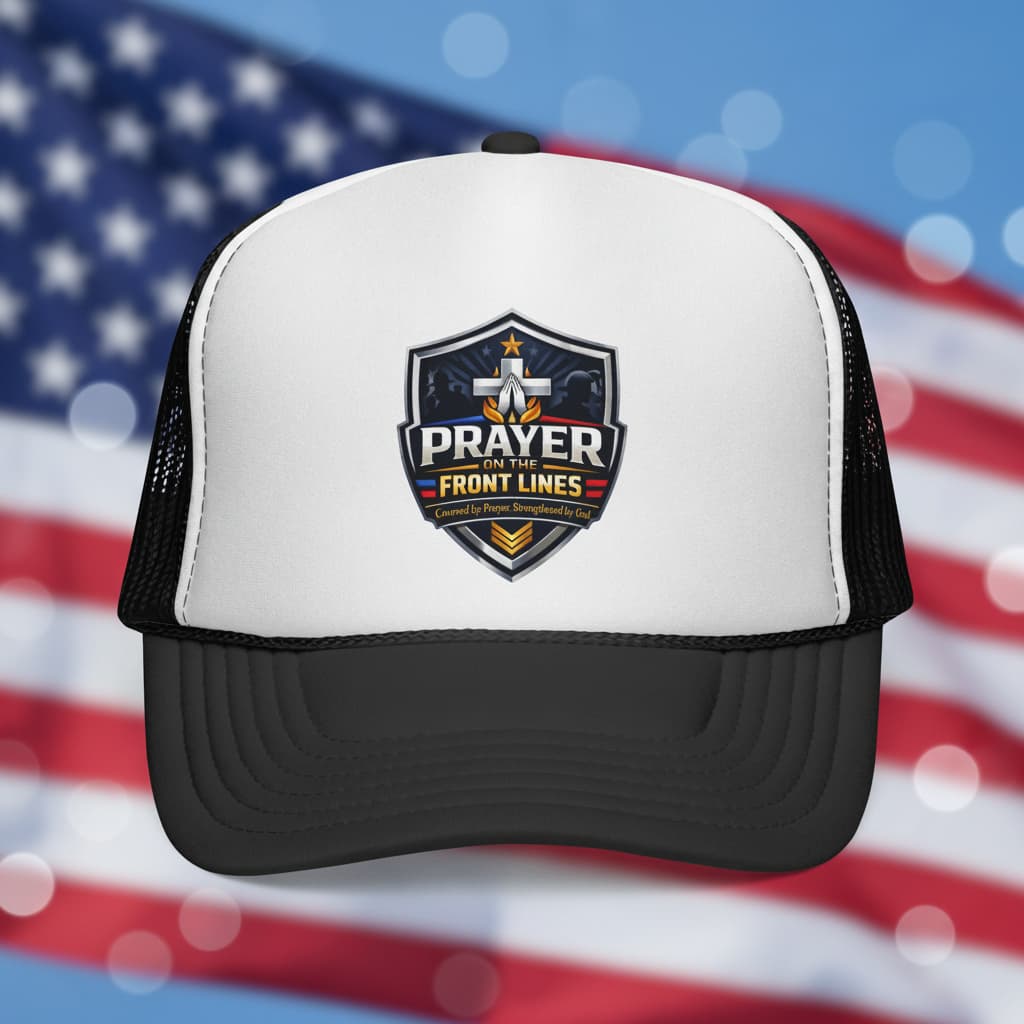 Trucker hat with 'Prayer on the Front Lines' shield logo against a blurred American flag.