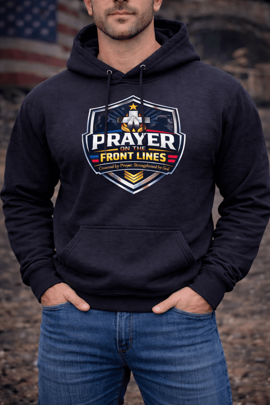 Man in a black hoodie with a 'Prayer on the Front Lines' shield and cross.