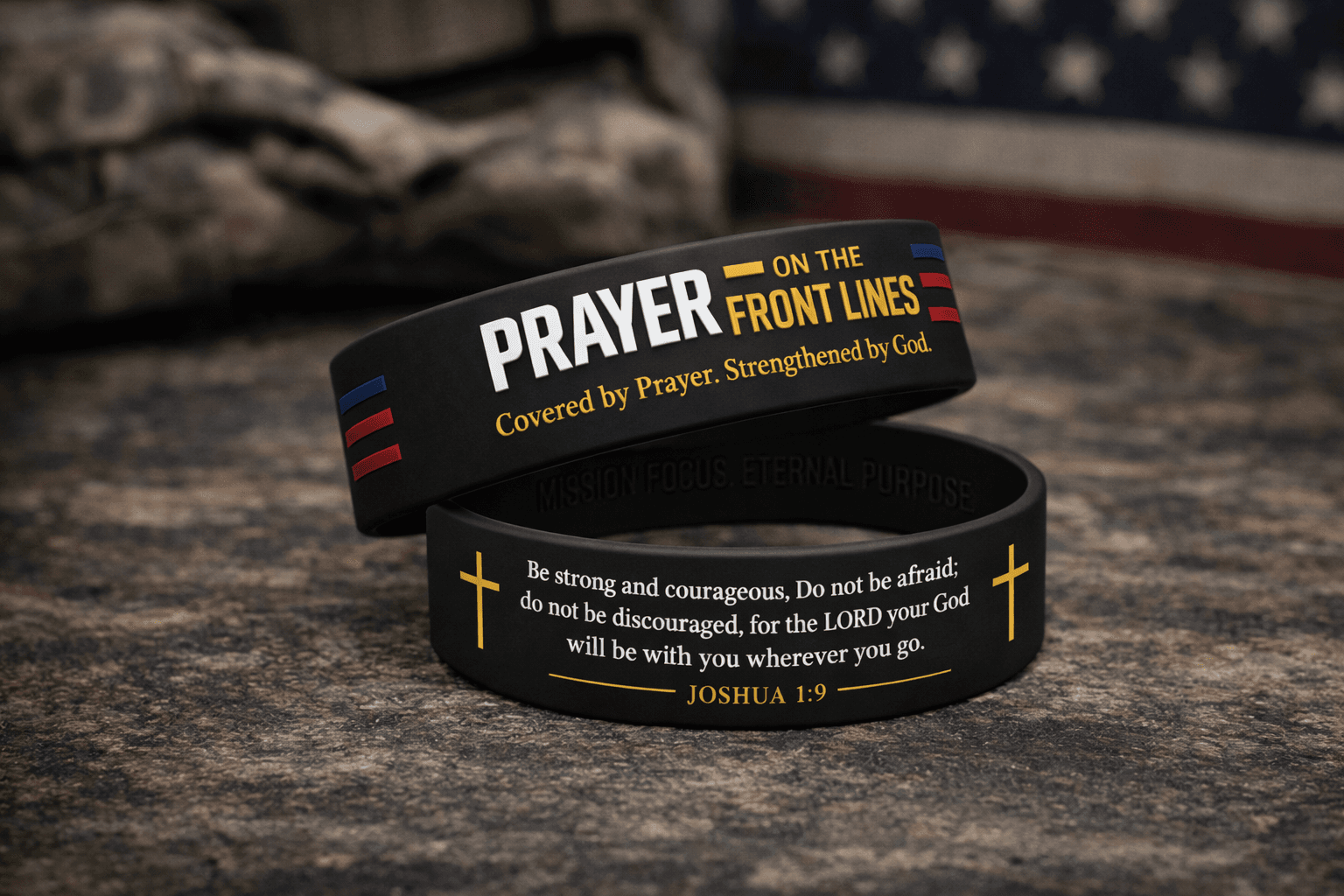 Two black wristbands with religious quotes and Joshua 1:9 against camouflage and American flag.